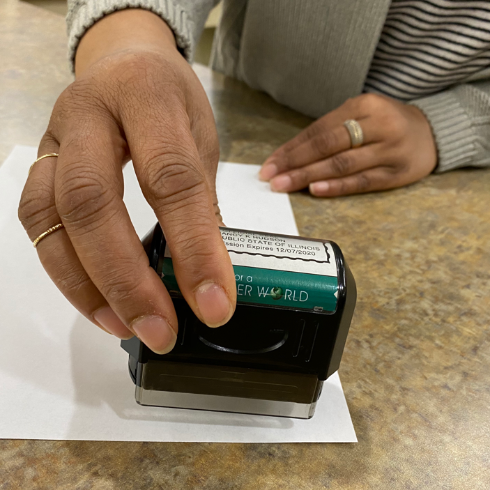 A person using a notary stamp
